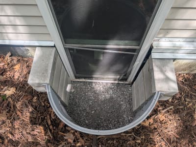Window well after repair, gravel drainage installed and area cleaned out — after